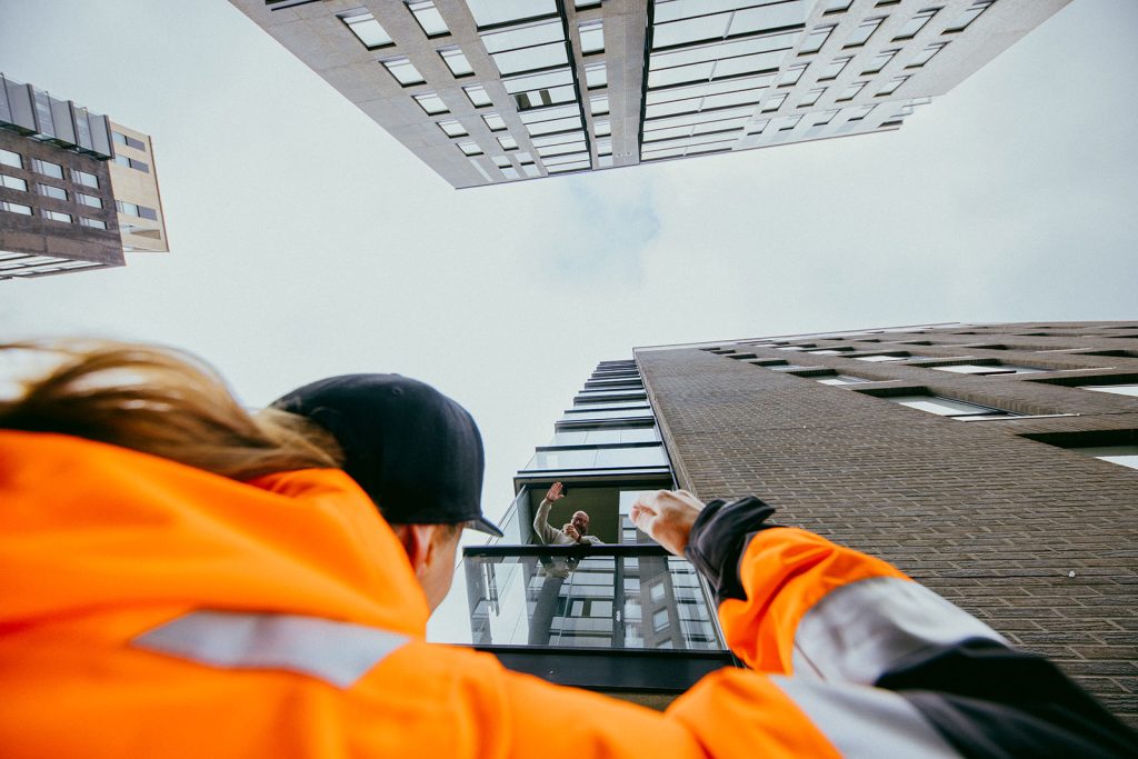 Kiinteistönhoitaja vilkuttaa miehelle parvekkeella
