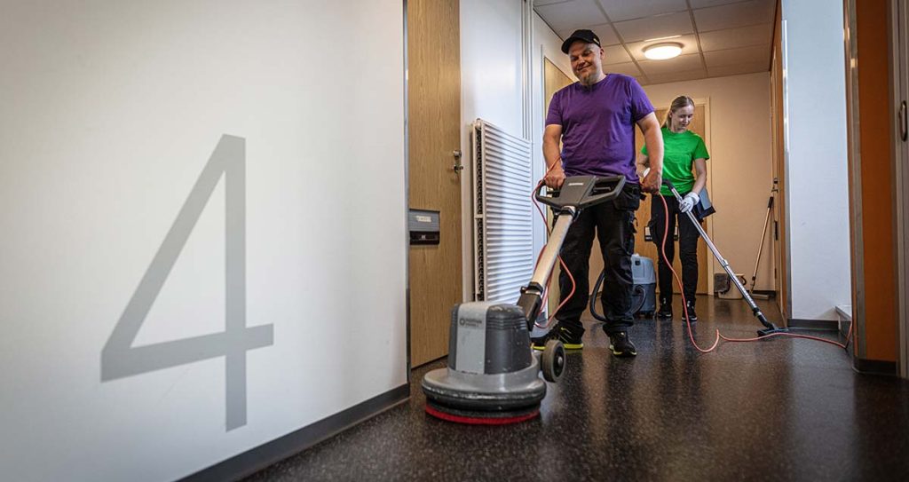 Mies ja nainen siivoavat rappukäytävää