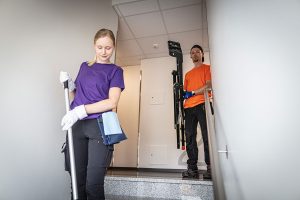 Nainen lakaisee rappukäytävää