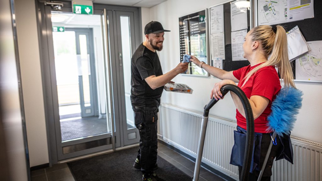 Mies ja nainen siivoavat porraskäytävää