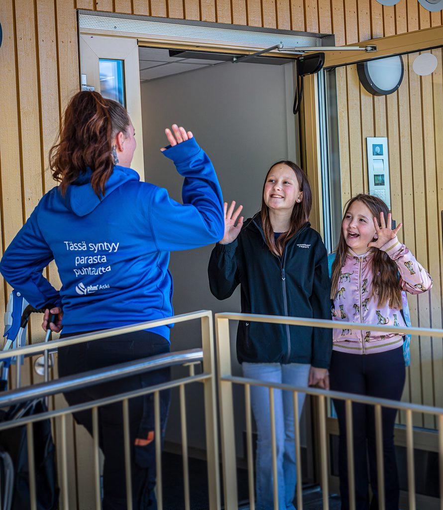 PHM Askin siivooja vilkuttaa kahdelle nuorelle työtölle